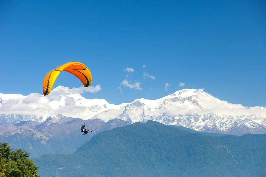 A tandem paraglider takes off over Pokhara,